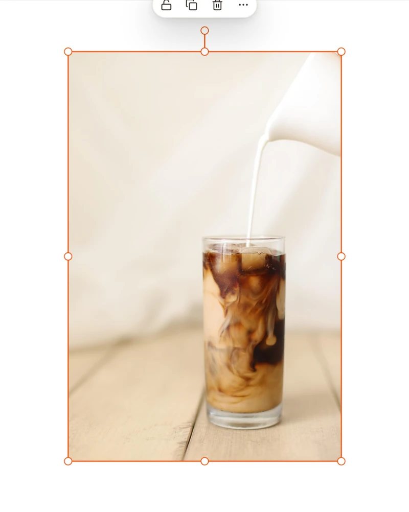Before: a stock photo of milk being poured into an iced coffee, with a blurred background.