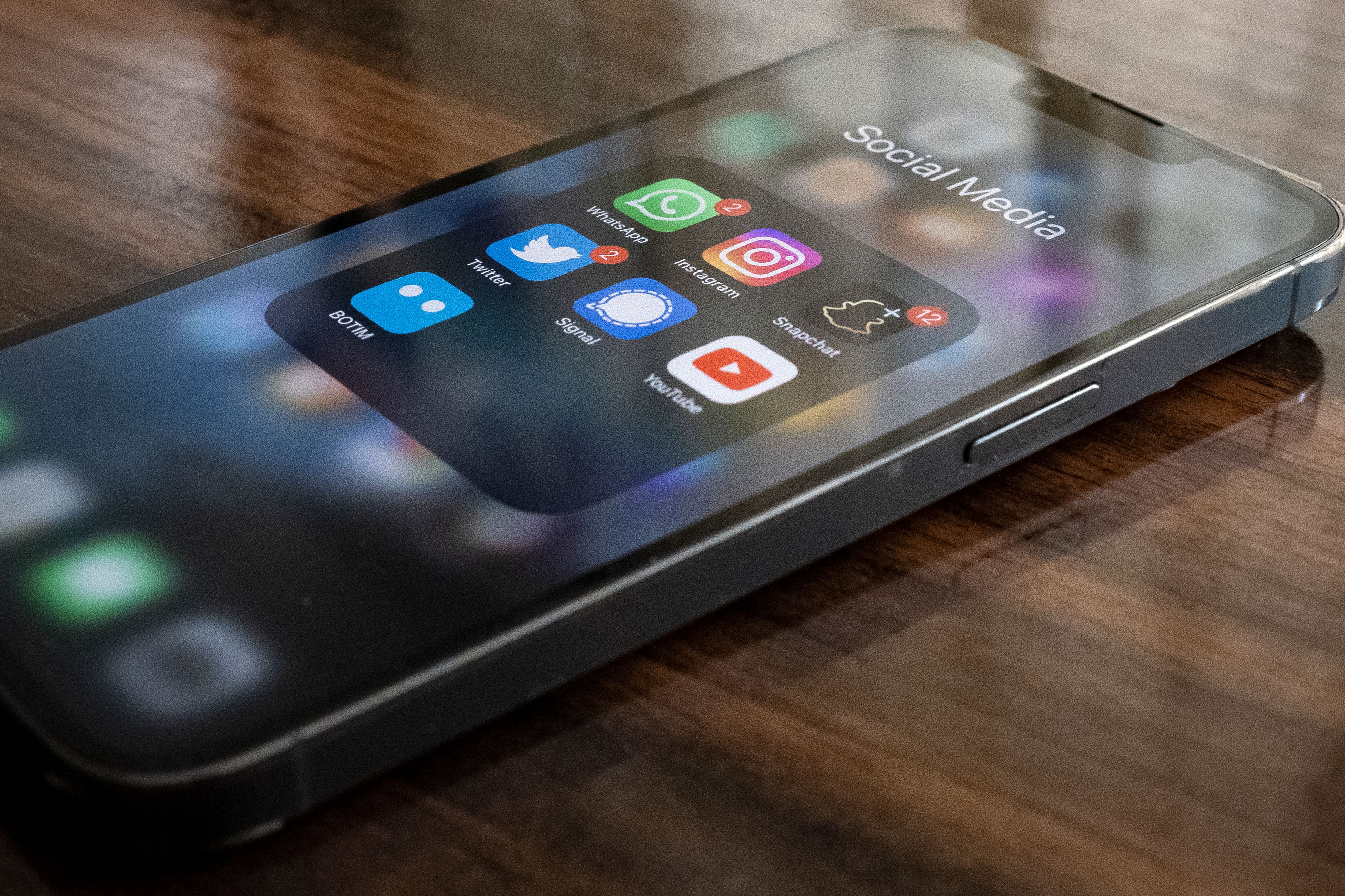 Smartphone on a table showing social media app icons, illustrating the benefits of AI in social media