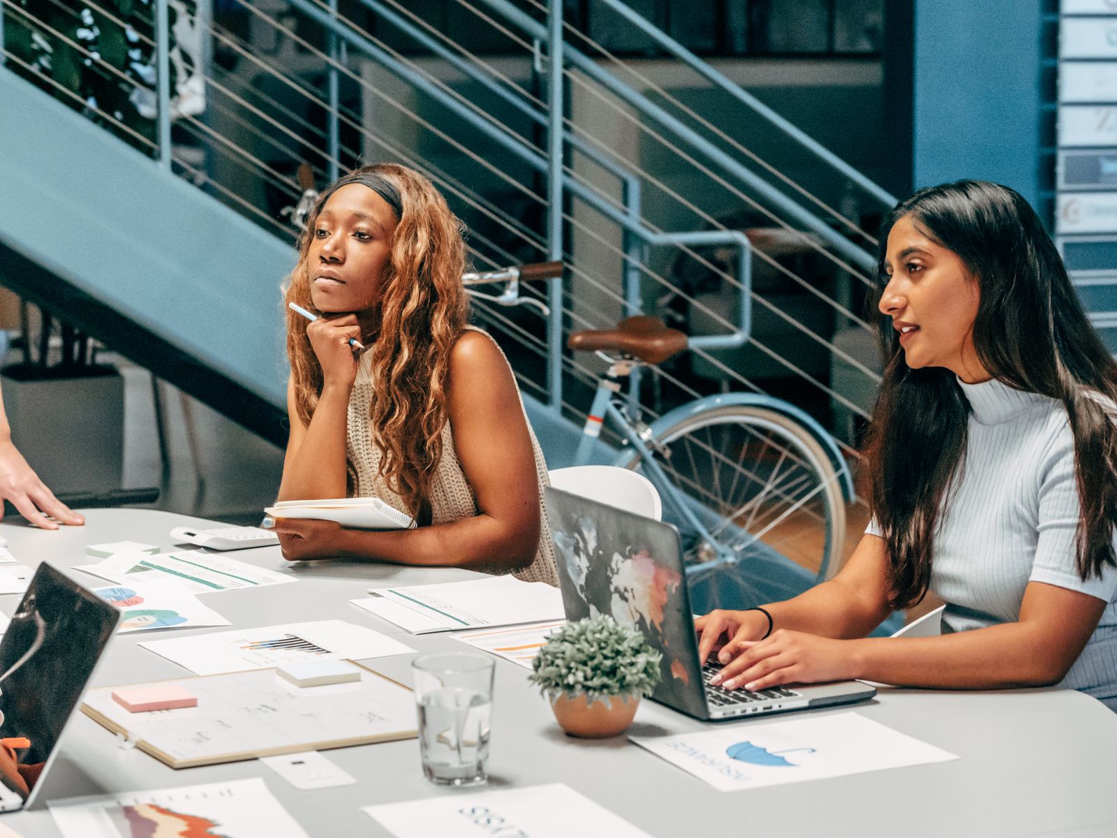 Marketing team at an office desk reviewing AI agent drafts for social media marketing
