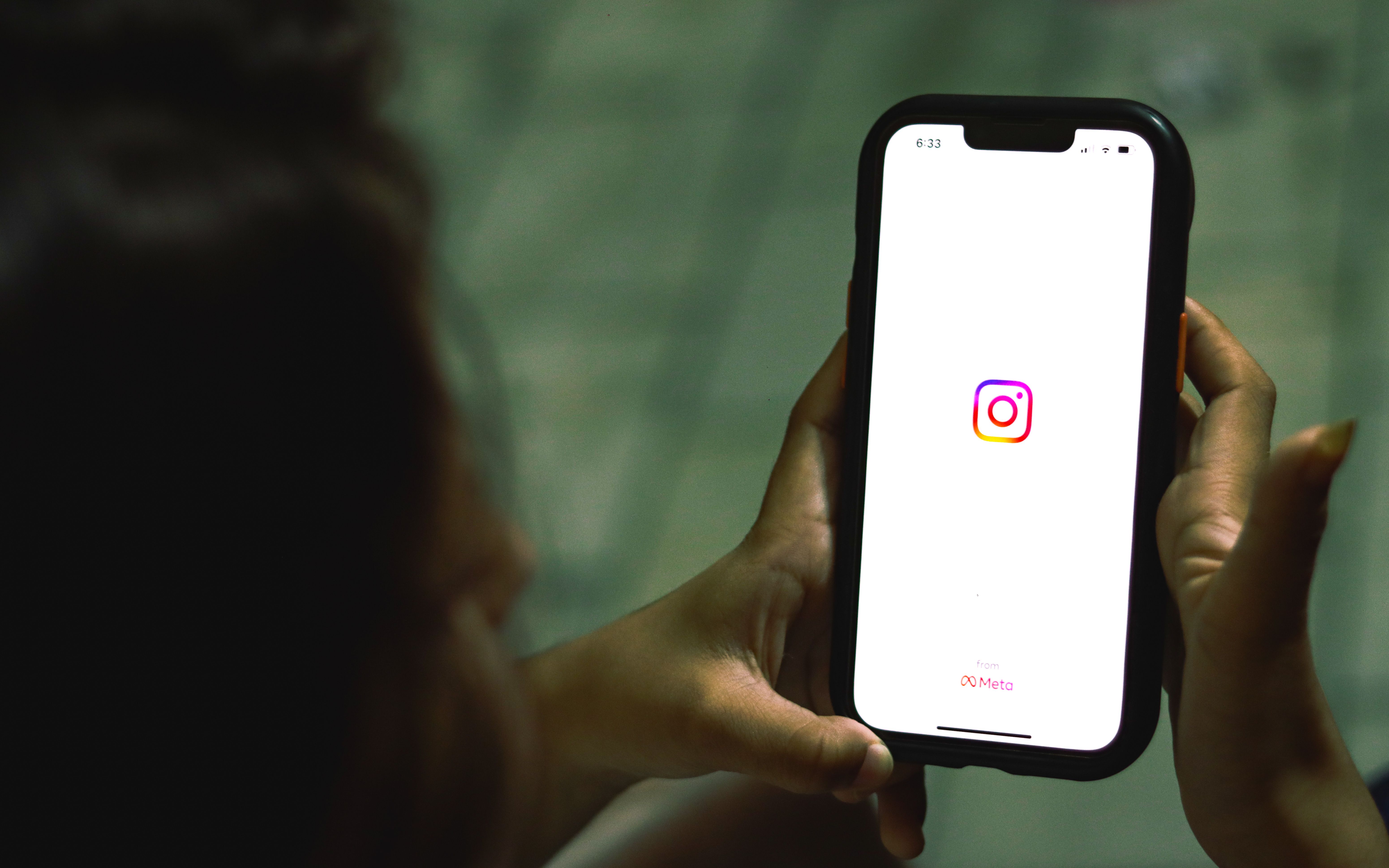 Hand holding a smartphone with the Instagram app on screen, choosing the best hashtags for Instagram