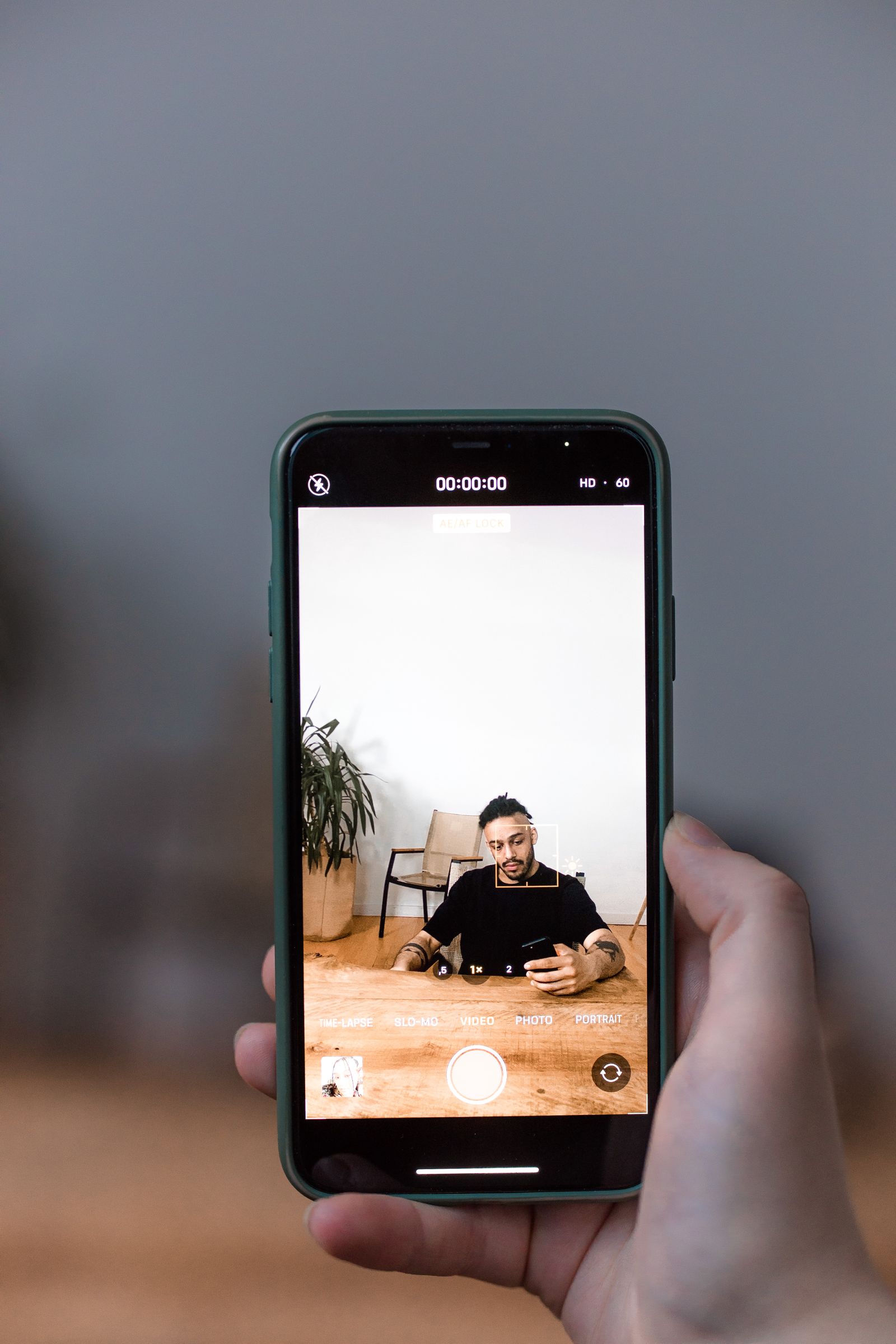 Hand holding a smartphone recording a vertical video, the kind of clip you can schedule as a YouTube Short