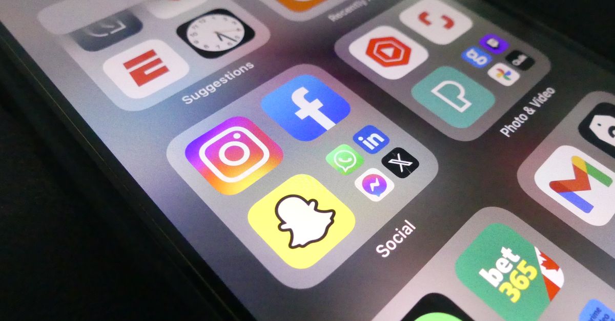 Smartphone screen showing social media apps where a free AI post generator can publish content