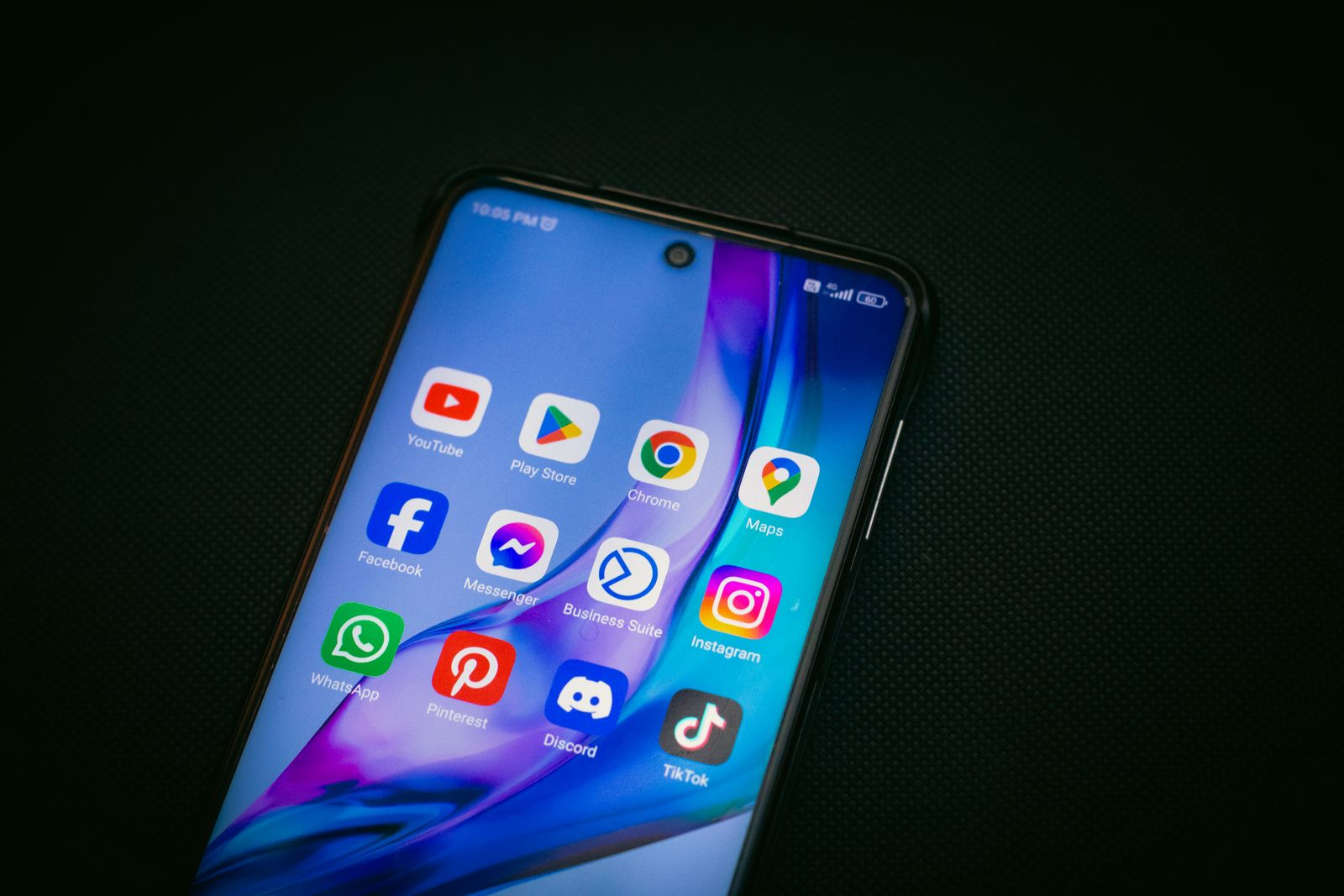 Smartphone screen with social media app icons, illustrating how to calculate engagement rate on Instagram