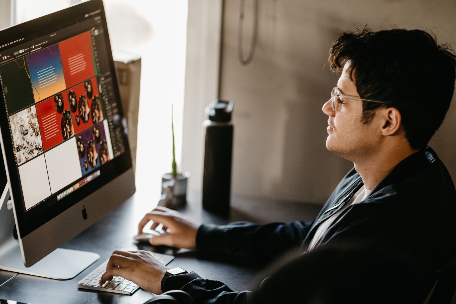 Designer creating graphics for social media on a desktop computer in a modern office
