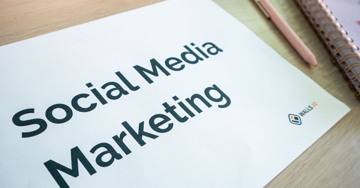 Social media content planning document on a desk with a pen and notebook