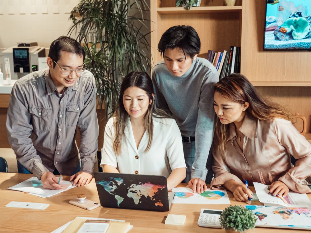 Social media manager onboarding a new client during a kickoff meeting around a laptop