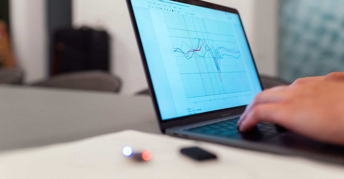 Marketer reviewing a social media report with performance graphs on a laptop